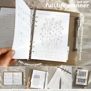 May include: A tan leather-bound planner with a silver ring binder. The planner is open to a mood tracker page with a floral illustration. The text "get our full life planner" and "build your dream planner" are visible.
