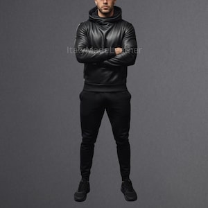 May include: A person wearing a black leather hoodie with a high collar and matching black pants. The hoodie has a sleek, modern design. The outfit is all black, creating a monochromatic look. The person is standing in front of a gray background.