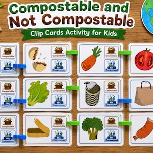 Könnte beinhalten: Lehrkarten für Kinder mit dem Titel "Kompostierbar und nicht kompostierbar". Die Karten zeigen Illustrationen verschiedener Gegenstände wie Tomaten, Karotten und Papiertüten, sortiert mit grünen und blauen Klammern.