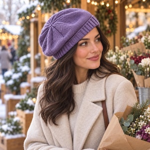 Könnte beinhalten: Eine lavendelfarbene Strickbaskenmütze mit geripptem Rand und einem strukturierten, radialen Stichmuster, das in der Mitte zusammenläuft. Die Mütze besteht aus weichem Garn und zeigt eine klassische, abgerundete Form mit einem festen Rand.