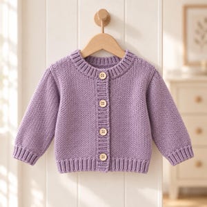 May include: A light purple knitted cardigan featuring a ribbed crew neckline, ribbed cuffs, and a ribbed hem. The garment is fastened down the center front with four round, light-colored wooden buttons. The sweater is displayed on a wooden hanger.