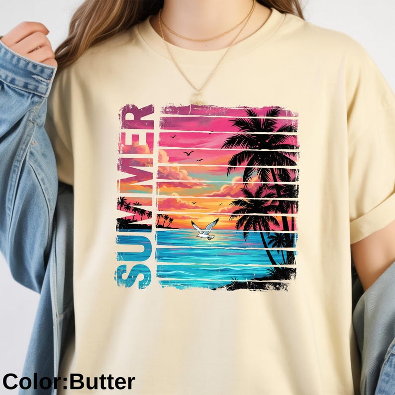 May include: Butter-colored t-shirt featuring a vibrant summer scene. The design includes a sunset over the ocean, palm trees, and the word "SUMMER" in vertical, colorful letters. A seagull flies over the water.