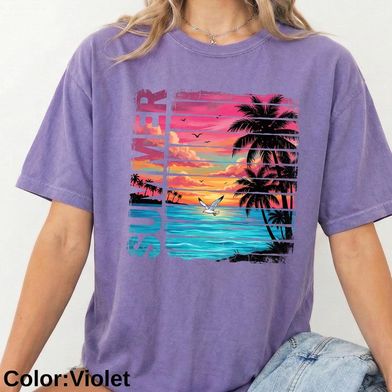 May include: Violet-colored t-shirt featuring a vibrant tropical sunset design. The graphic includes palm trees, a seagull, and the word "SUMMER" in a colorful, vertical font. The shirt is a comfortable, casual style.