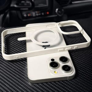 Könnte beinhalten: Ein weißes iPhone 13 Pro Max mit einer weißen Schutzhülle und einem MagSafe-Ring. Das Telefon hat drei Kameralinsen und einen silbernen Rahmen. Die Hülle hat einen erhöhten Rand zum Schutz des Bildschirms.