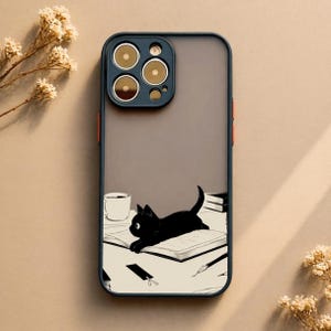 Peut inclure: Coque de téléphone avec un chat noir allongé sur un livre, une tasse à café et des livres. Le boîtier a un fond gris avec un bord bleu foncé et des accents orange. L'illustration du chat est en noir et blanc.