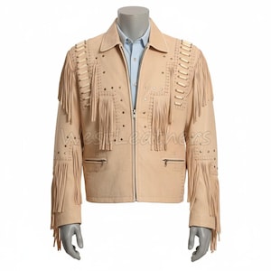 Pode incluir: Casaco de camurça bege com franjas nas mangas e no peito. O casaco tem fecho de correr, dois bolsos frontais e tachas decorativas. O casaco é exibido em um manequim e tem o texto "west Leathers" na frente.
