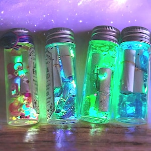 May include: Four small glass bottles with silver lids, each filled with colorful, glowing liquid and small rolled-up scrolls. The bottles have a magical, ethereal appearance, with shades of green, blue, and yellow.