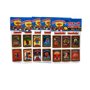 Peut inclure: Un paquet de feuilles d'autocollants Garbage Pail Kids avec 12 autocollants différents. Chaque autocollant présente un personnage différent de la série Garbage Pail Kids. Les autocollants sont sur un fond blanc avec une bordure bleue. Le texte "Garbage Pail Kids Stick-On Pictures" est imprimé sur le devant du paquet.