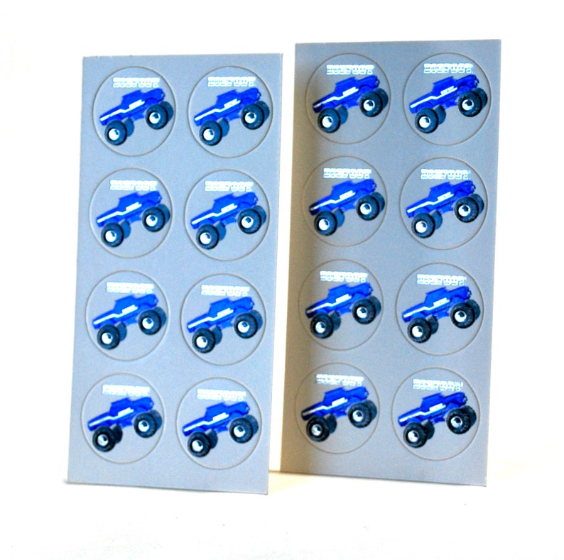 May include: Two sheets of stickers featuring a blue monster truck design. Each truck is in a gray circle with the word "BIGFOOT" above it. The trucks have black tires and white accents. The stickers are on a white background.
