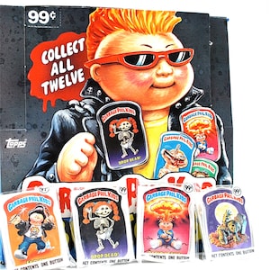 May include: A box of Garbage Pail Kids trading cards featuring a cartoon character with red hair and sunglasses. The box has the text "Collect All Twelve" and "99¢". The cards are individually packaged in plastic wrappers with the text "Garbage Pail Kids" and "Drop Dead!" on them.