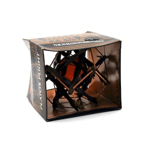 May include: A boxed puzzle game, "Plato's Flight," features a geometric wooden structure with a central orange sphere. The box is brown with gold accents and the text "The Philosopher's Puzzle."