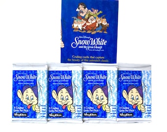 Puede incluir: Cuatro paquetes de cartas coleccionables de Blancanieves y los Siete Enanitos. Cada paquete presenta un fondo azul con una imagen de dibujos animados de Doc, uno de los siete enanitos, y el texto "8 Trading Cards Per Pack" y "SkyBox".