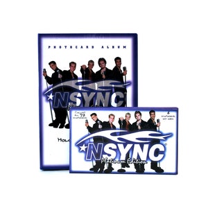 May include: A blue and white photocard album with the text "PHOTOCARD ALBUM" and "NSYNC" on the front. The album is closed and has a picture of the band NSYNC on the front. The album is next to a smaller blue and white photocard pack with the text "NSYNC Platinum Edition" on the front. The pack has a picture of the band NSYNC on the front. The pack has the text "6 photocards per pack" on the front.