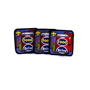 May include: Three purple and blue embroidered patches with a red and white can of food with the words "Food Drive" on it. Each patch has a gold fleur-de-lis.