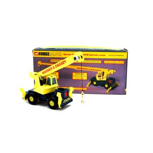 May include: A yellow and black Corgi Major Warner & Swasey 4418 hydraulic crane toy. The crane has a long extending boom and a hook. The box behind the crane shows a picture of the crane and the words "Warner & Swasey".