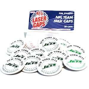 Può includere: Venti tappi rotondi bianchi per bottiglie di latte con un logo verde dei New York Jets e il testo "AFC Eastern Division".