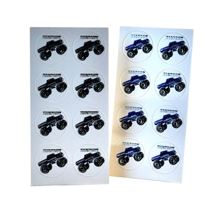May include: Two sheets of circular stickers featuring a black monster truck design with the text "Monster Jam" in white. The monster trucks have large tires and are set against a white background. The stickers are likely for party favors or crafts.