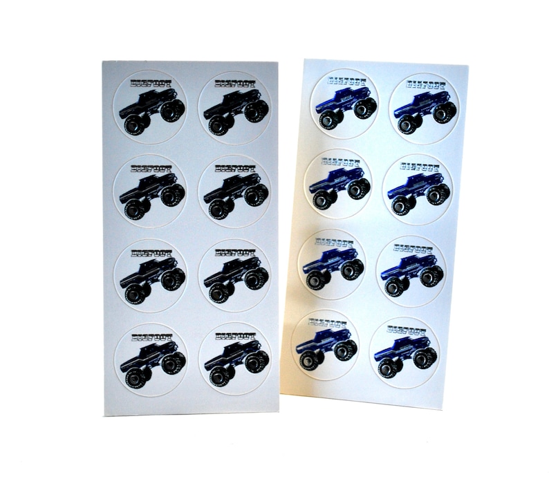 May include: Two sheets of circular stickers featuring a black monster truck design with the text "Monster Jam" in white. The monster trucks have large tires and are set against a white background. The stickers are likely for party favors or crafts.
