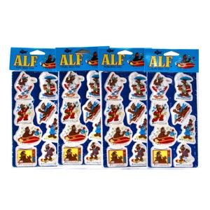 May include: Four packs of ALF puffy stickers. Each pack contains 8 stickers featuring ALF in various poses. The stickers are on a blue background with the words "ALF" and "Puffy Stick-Ons" printed on the front.