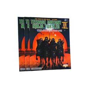May include: Three Teenage Mutant Ninja Turtles sticker albums with a red and orange sunset background. The turtles are riding horses and the text on the cover reads "Teenage Mutant Ninja Turtles II".