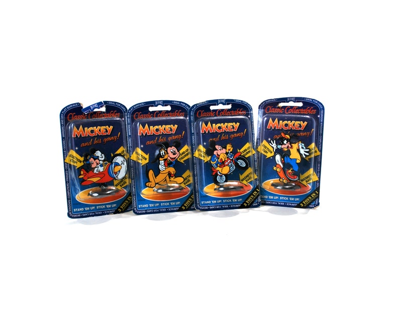 Puede incluir: Cuatro paquetes de cart&oacute;n azul y amarillo con el texto "Classic Collectables" y "MICKEY and his gang!" Cada paquete presenta una imagen de dibujos animados diferente de Mickey Mouse y sus amigos. Los paquetes est&aacute;n etiquetados con "3 TOYS IN 1" y "STAND 'EM UP STICK 'EM UP".