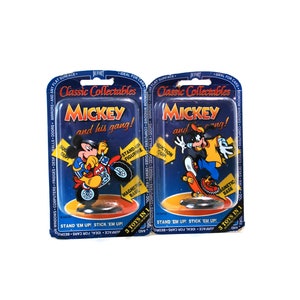 Puede incluir: Dos bl&iacute;ster de pl&aacute;stico con figuras de Mickey Mouse y Goofy. Las figuras est&aacute;n en una motocicleta y una patineta. El empaque dice "Classic Collectables Mickey and his gang!" y "3 Toys in 1".