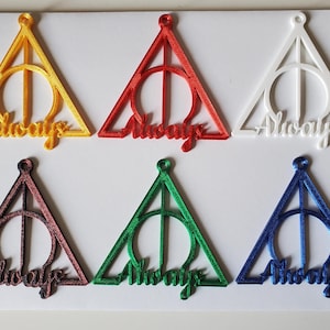 May include: Six colorful Deathly Hallows symbols in yellow, red, white, maroon, green, and blue. Each triangle has a circle and a vertical line, with the word "Always" below. The symbols are on a white background.