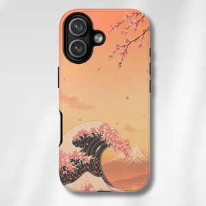 以下が含まれることがあります： 日本のデザインをモチーフにしたスマホケース。 桜の花、山、夕焼け空と、様式化された波が描かれています。 ケースは黒い縁取りで、カメラの切り抜きがあります。