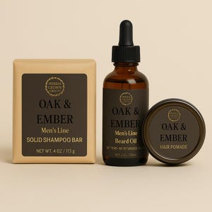 May include: A set of grooming products from the "Oak & Ember Men's Line." Includes a solid shampoo bar (4 oz), beard oil (2 oz), and hair pomade. The products have dark brown labels with gold text and are packaged in a neutral-toned setting.