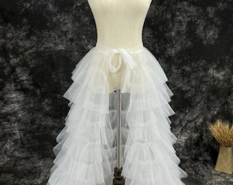 Cette élégante jupe en tulle superposé blanc est parfaite pour ajouter une touche de sophistication à n'importe quelle tenue. Son design fluide crée un effet gracieux