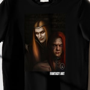 Op de afbeelding: Zwart t-shirt met een fantasy art print. De afbeelding toont twee figuren met lang haar, &eacute;&eacute;n blond en &eacute;&eacute;n roodharig, in een donkere, gotische stijl. De tekst "FANTASY ART" staat eronder.