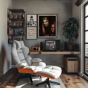 Op de afbeelding: Een moderne thuiskantooropstelling met een grijze en witte ergonomische stoel met oranje accenten en een bijpassende voetensteun. Een houten bureau herbergt een computer, luidsprekers en een radio in vintage-stijl. Kunstwerken en een boekenrek maken de kamer compleet.