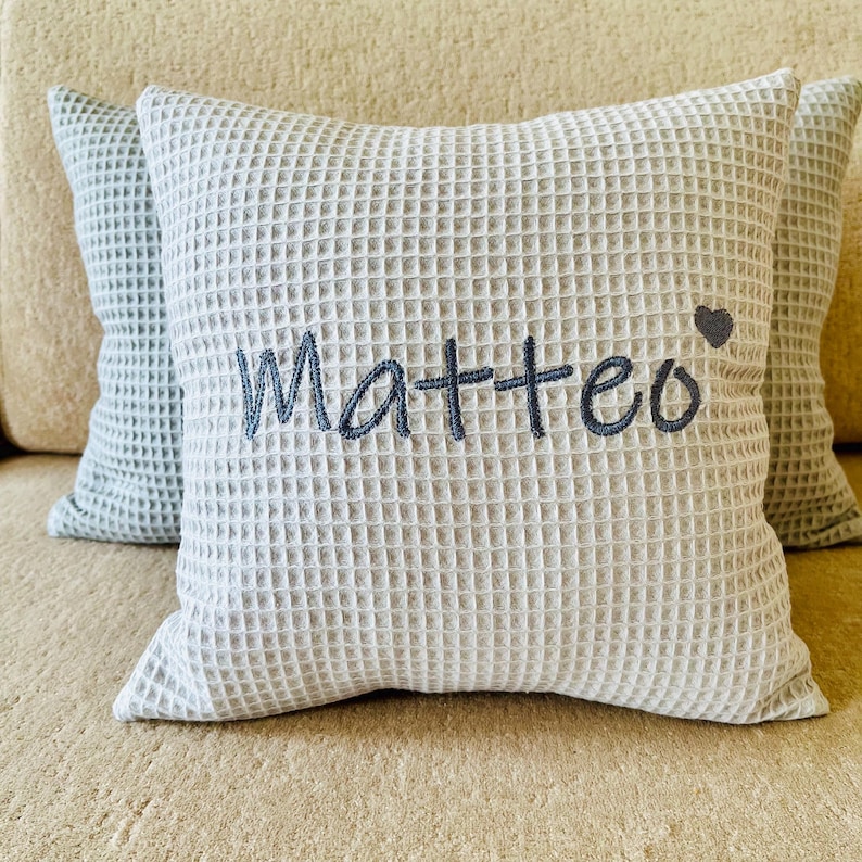 A super soft handcrafted waffle weave cushion with custom name embroidery, perfect personalized gift for baby boys and nursery decor.

Ein supersaftes handgemachtes Waffelkissen mit Namensstickerei, perfektes personalisiertes Geschenk für Jungen und Babyzimmer-Dekoration.

Un coussin gaufré artisanal ultra doux avec prénom brodé, cadeau personnalisé parfait pour petit garçon et décoration de chambre d'enfant.