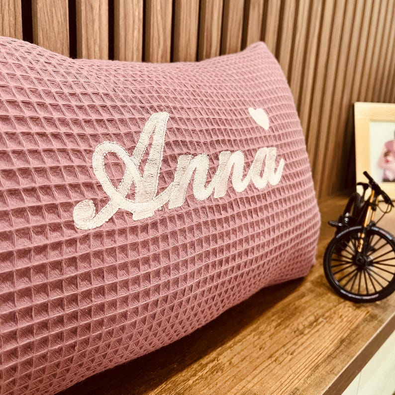 Handcrafted dusty rose waffle weave cushion with fine name embroidery, premium cotton fabric, and a hidden zip closure for baby room decor.

Handgemachtes Waffelkissen in Altrosa mit feiner Namensstickerei, hochwertigem Baumwollstoff und nahtverdecktem Reißverschluss für das Babyzimmer.

Coussin artisanal gaufré vieux rose avec broderie personnalisée du prénom, coton de qualité supérieure et fermeture éclair discrète.