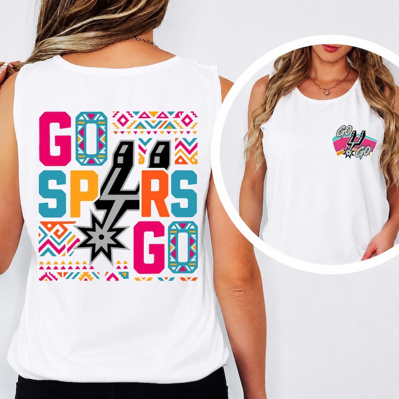 Puede incluir: Una camiseta sin mangas blanca con un gr&aacute;fico grande en la espalda que incluye el texto GO SPURS GO en letras de colores y patrones geom&eacute;tricos. Una versi&oacute;n m&aacute;s peque&ntilde;a del gr&aacute;fico est&aacute; impresa en la parte frontal izquierda del pecho.