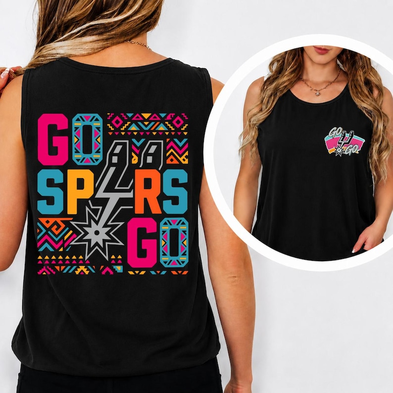 Puede incluir: Una camiseta sin mangas negra con un gr&aacute;fico grande en la espalda con el texto GO SPURS GO en rosa, naranja y azul, acentuado por patrones geom&eacute;tricos y un logotipo de espuela plateado. Un gr&aacute;fico m&aacute;s peque&ntilde;o a juego est&aacute; en el pecho.