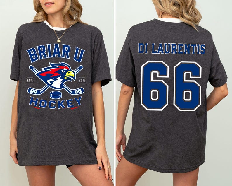 May include: A dark charcoal gray short-sleeve t-shirt. The front features a Briar U Hockey logo with a hawk, hockey sticks, and a puck. The back displays the name Di Laurentis and the number 66 in large blue font with white outlines.