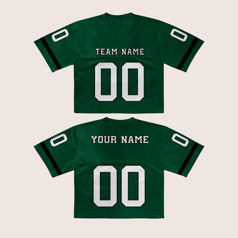 Puede incluir: Dos camisetas de f&uacute;tbol verdes con n&uacute;meros y letras blancas. La camiseta delantera dice "TEAM NAME" encima del n&uacute;mero "00". La camiseta trasera dice "YOUR NAME" encima del n&uacute;mero "00". Cada camiseta tiene una franja negra en las mangas.