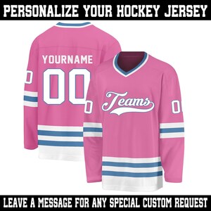 May include: Two pink hockey jerseys with white and blue accents. One jersey displays the name "YOURNAME" and the number "00". The other jersey has the word "Teams" and the number "0". The text "PERSONALIZE YOUR HOCKEY JERSEY" and "LEAVE A MESSAGE FOR ANY SPECIAL CUSTOM REQUEST" are also visible.