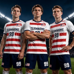 May include: Three soccer players wearing white jerseys with red horizontal stripes, the American flag, and the text "TEAMNAME 99." They are also wearing navy blue shorts with the number 99 and the American flag. The background is a soccer field.