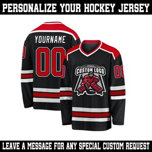 May include: Black hockey jersey with red and white accents. The jersey features the text "YOURNAME" and the number "00" on the back. The front displays a custom logo and the number "0". The text "PERSONALIZE YOUR HOCKEY JERSEY" is at the top.