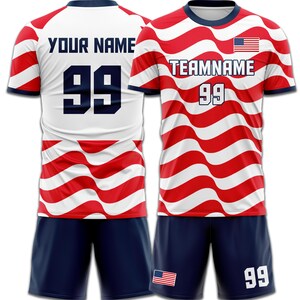 May include: A soccer uniform set featuring a red and white wavy striped jersey with the text "TEAMNAME" and the number "99". The shorts are navy blue. The jersey also has the American flag on it.