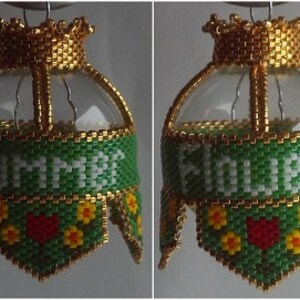 May include: Two beaded Christmas ornaments with gold crowns and green beaded banners. The banner on the left ornament reads "SUMMER" and the banner on the right ornament reads "HOLIDAYS".