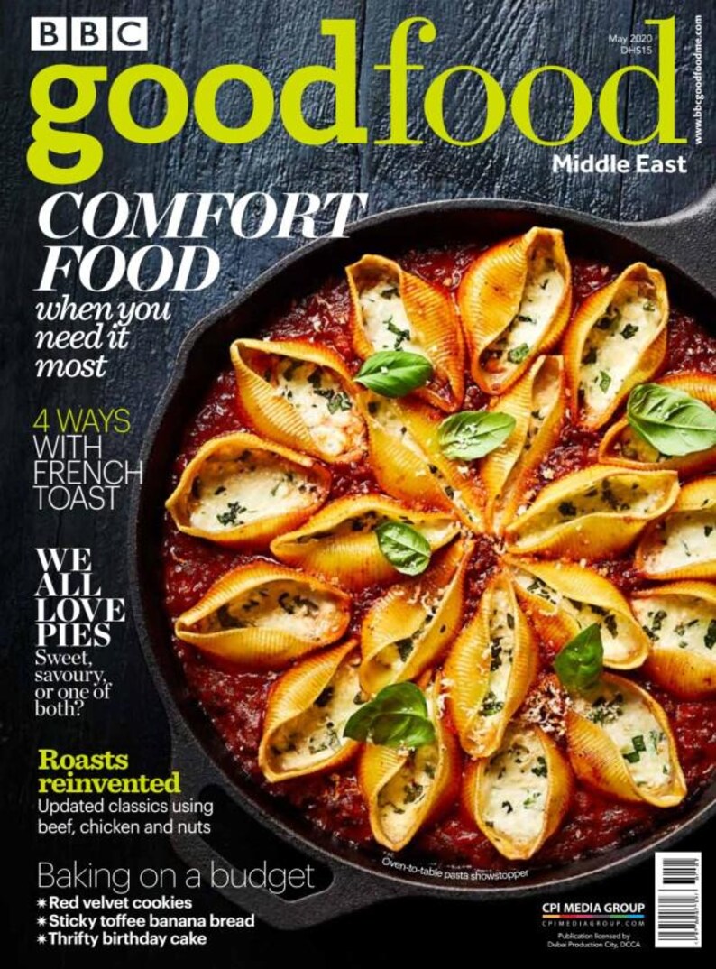 Puede incluir: La portada de la revista BBC Good Food presenta conchas de pasta rellenas de queso y hierbas, dispuestas en un patr&oacute;n circular en una sart&eacute;n de hierro fundido, con una base de salsa de tomate. Tambi&eacute;n se ven el t&iacute;tulo y el contenido de la revista.