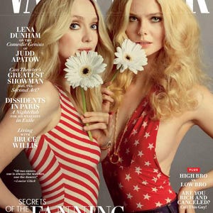 May include: Vanity Fair magazine cover featuring two women holding white flowers. One wears a red and white striped top, the other a red top with white stars. The cover text includes "Secrets of the Fanning Sisterhood."