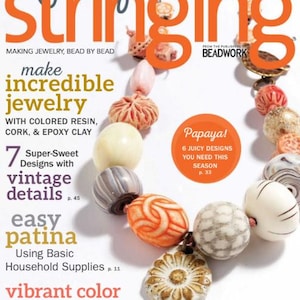 May include: The cover of "Jewelry Stringing" magazine features a necklace made of various beads in shades of white, orange, gray, and pink. The magazine cover has the title "Jewelry Stringing" in large orange letters and text that reads "make incredible jewelry".