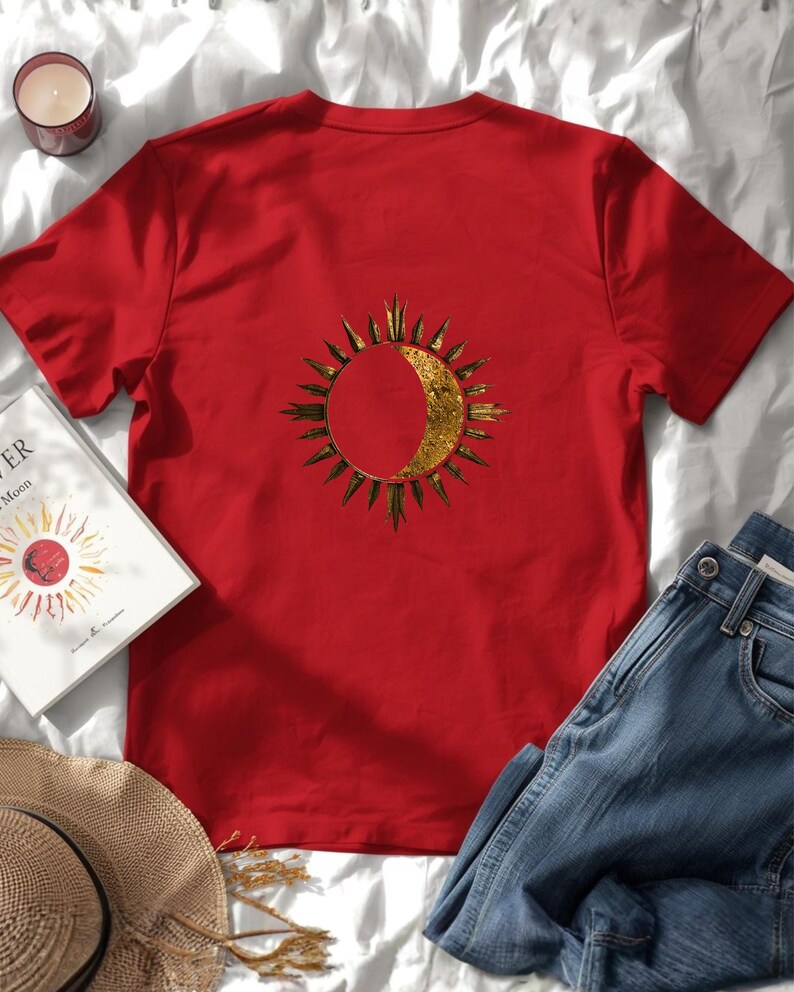 Flatlay of a organic cotton red tee with a big astrology sun and moon statement print on the back. Celestial zodiac design.