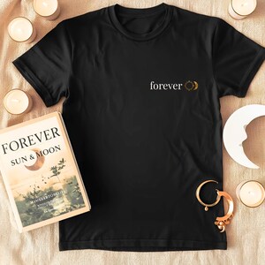 Flatlay of a organic cotton shirt with a small astrology chest print with FOREVER and sun and moon. Boho whitchy minimalist design.