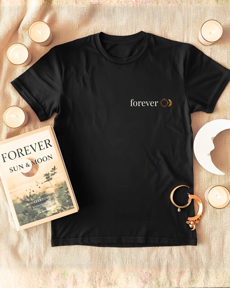 Flatlay of a organic cotton shirt with a small astrology chest print with FOREVER and sun and moon. Boho whitchy minimalist design.