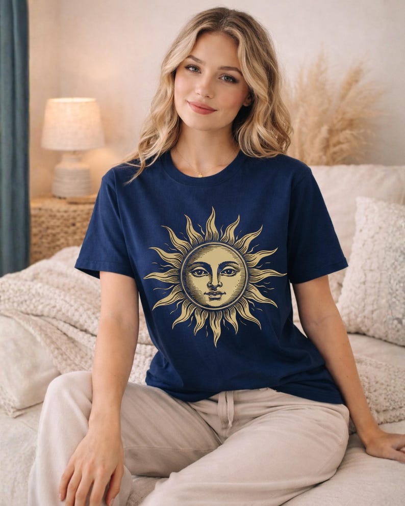 Woman sitting in a navy blue sun moon graphic tee with vintage celestial design, styled as a boho astrology shirt with a soft mystical aesthetic